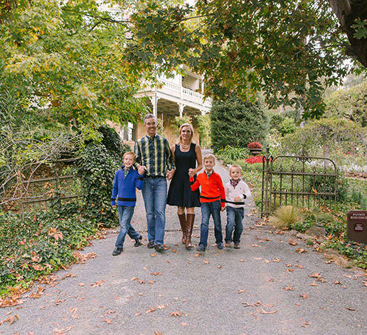 Hugh and Monique Davies and their three sons strolling through wrought iron gate of the historic Victorian house