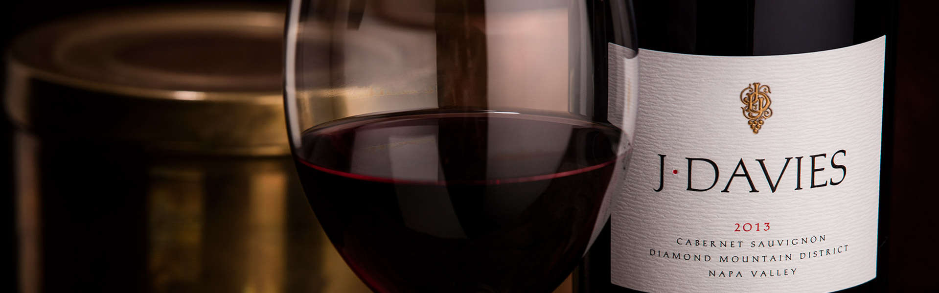 Full wine glass and bottle of J. Davies 2013 Estate Cabernet Sauvignon, Diamond Mountain District, Napa Valley