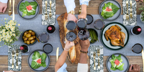 Toasting with glasses over table setting